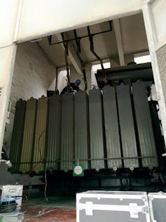 Several large pieces of metal machinery lined up in an underground facility.