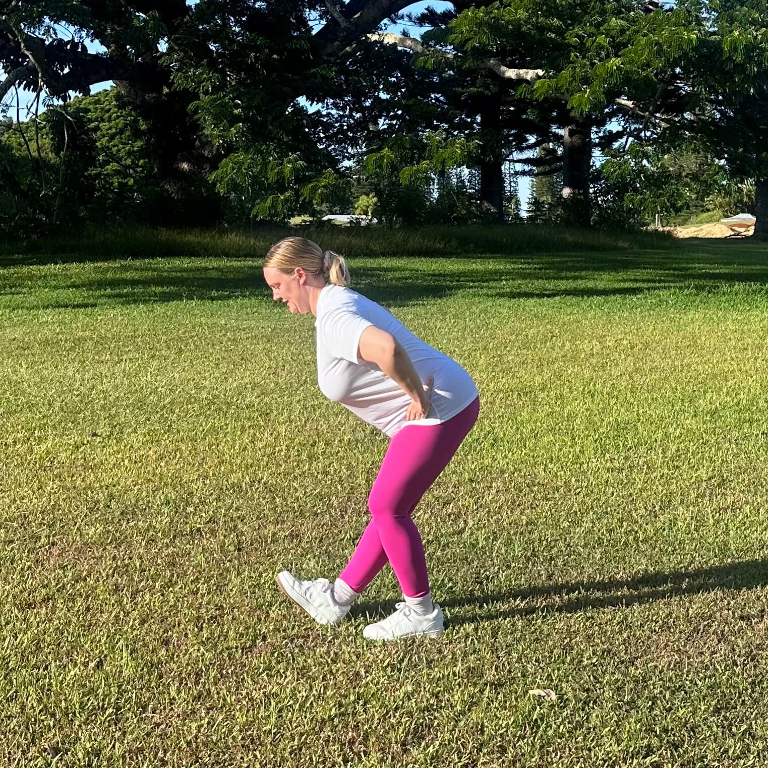 Woman demonstrating stretches on grass