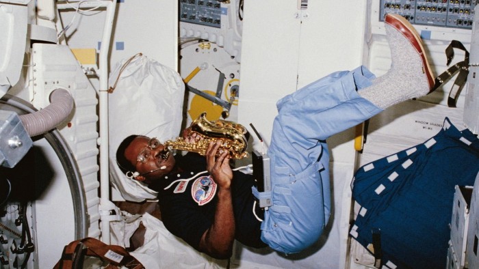 Astronaut plays a soprano saxophone while floating in the middeck of the Space Shuttle Challenger during STS-41B.