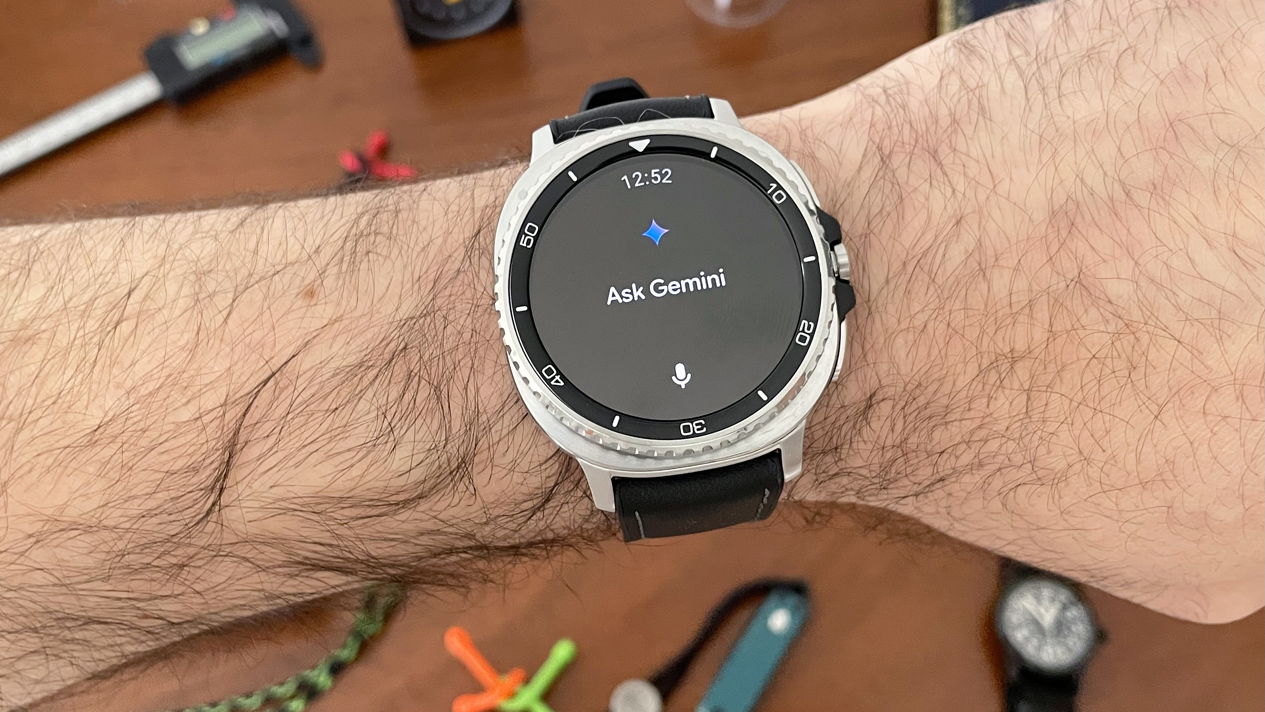 Close-up of the Samsung Galaxy Watch Classic on a user's wrist with the Gemini AI app open