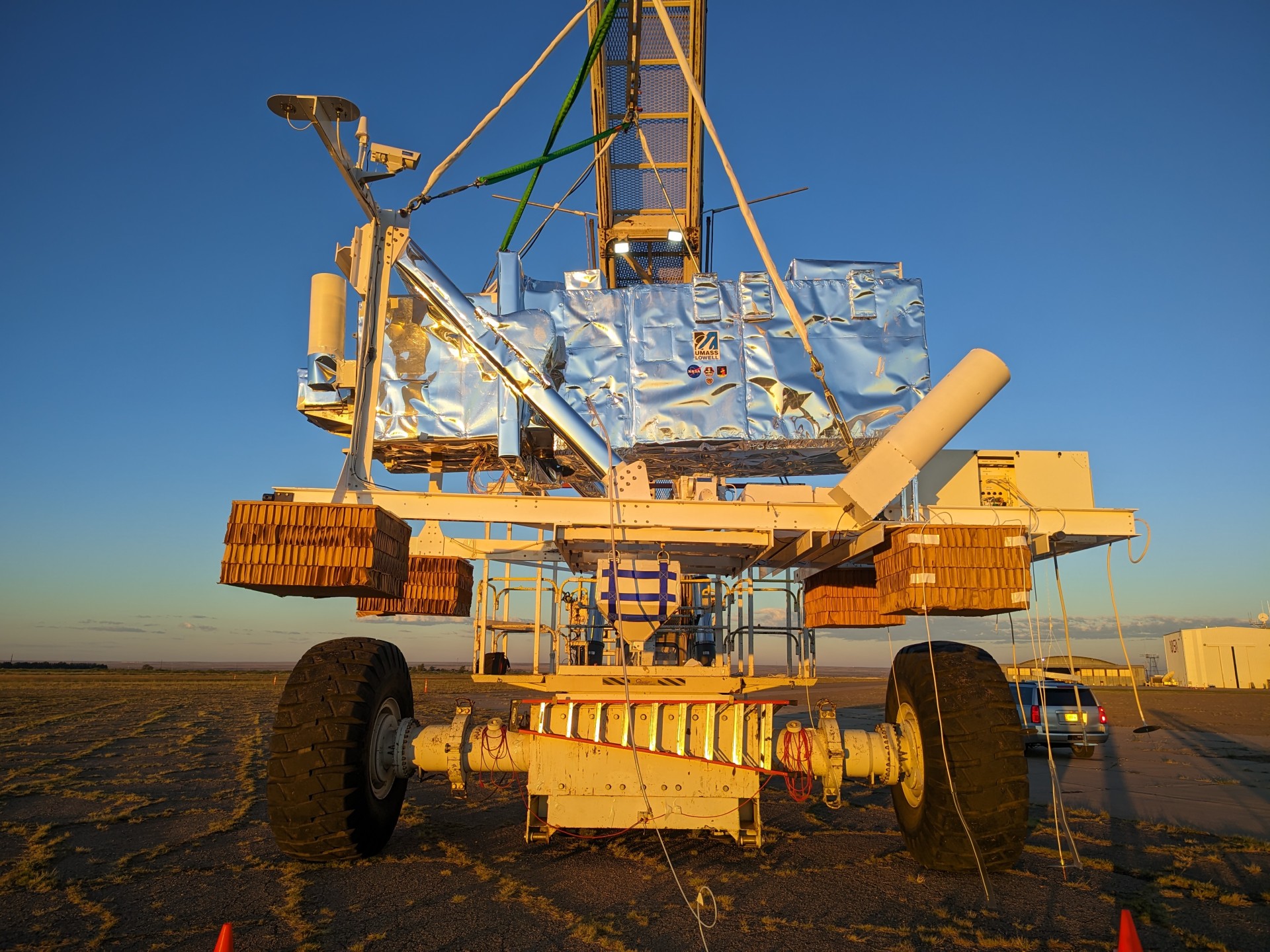 a silver rectangle on a crane in a field
