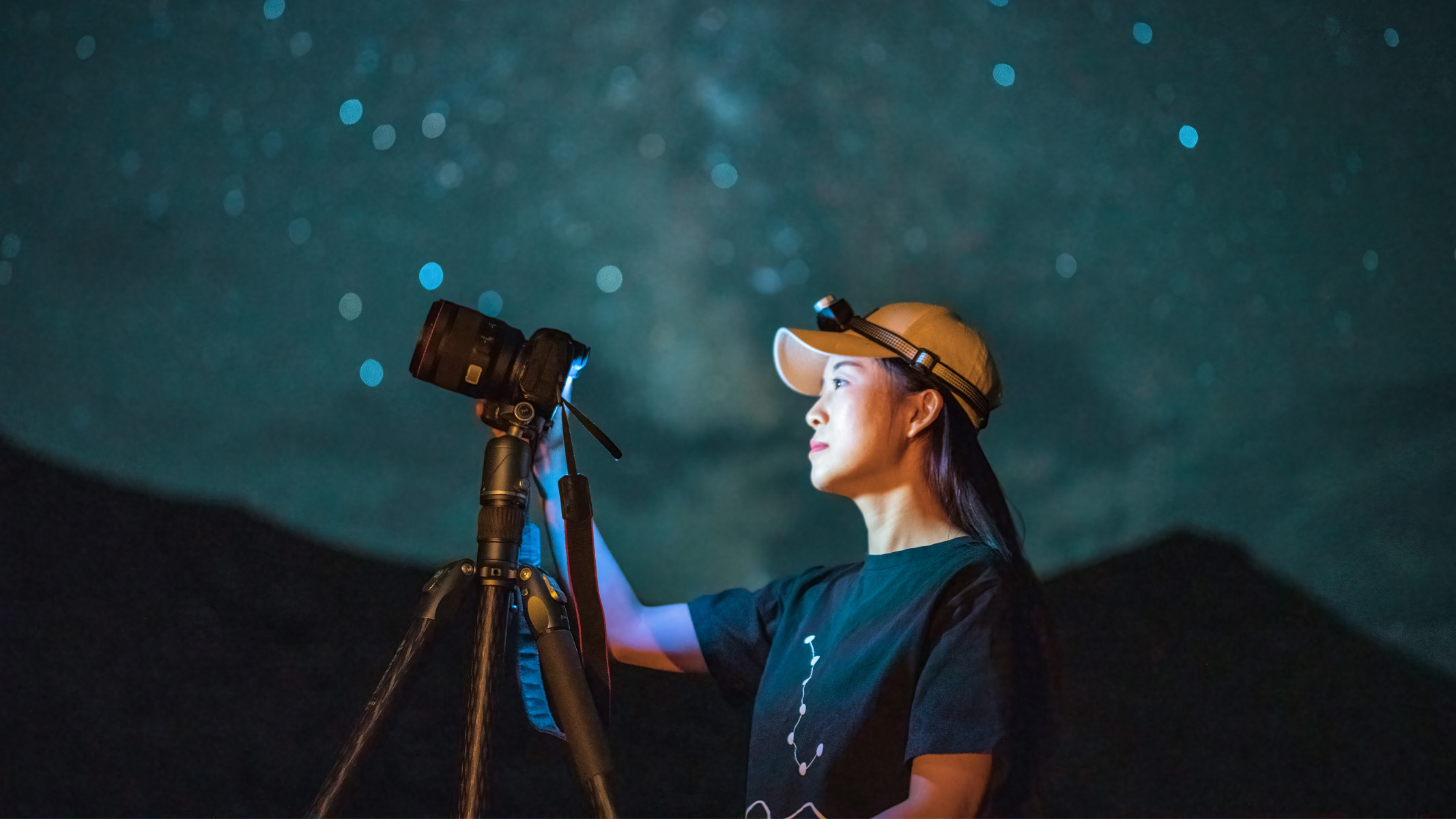 woman photographing the night sky with one of the best cameras for astrophotography