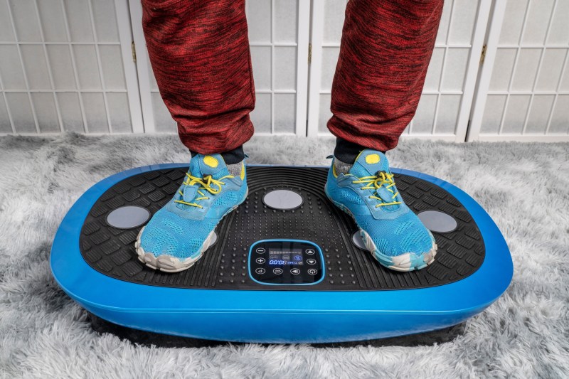 an blue sneakers on vibration plate working out indoors at home