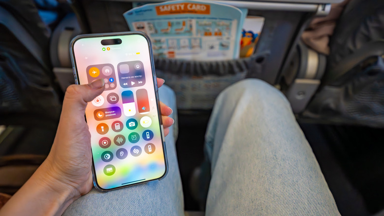 An airplane passenger enables airplane mode on their phone