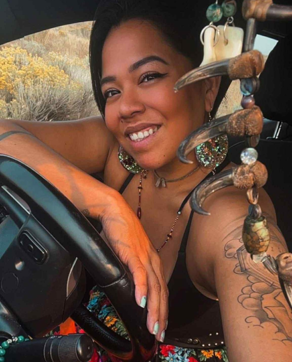 Indigenous woman smiles at camera.