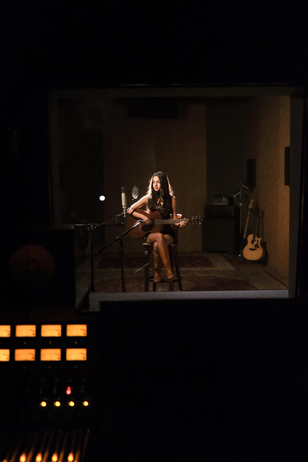 recording session with a musician playing guitar in a studio