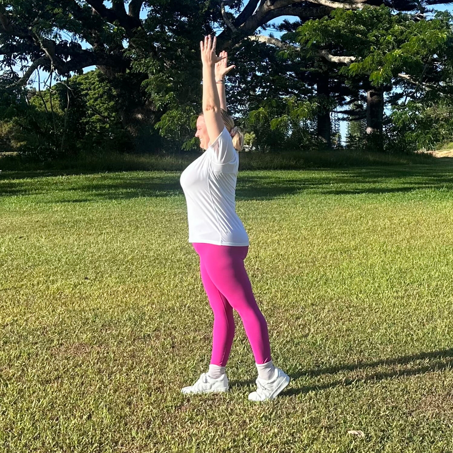 Woman demonstrating stretches on grass