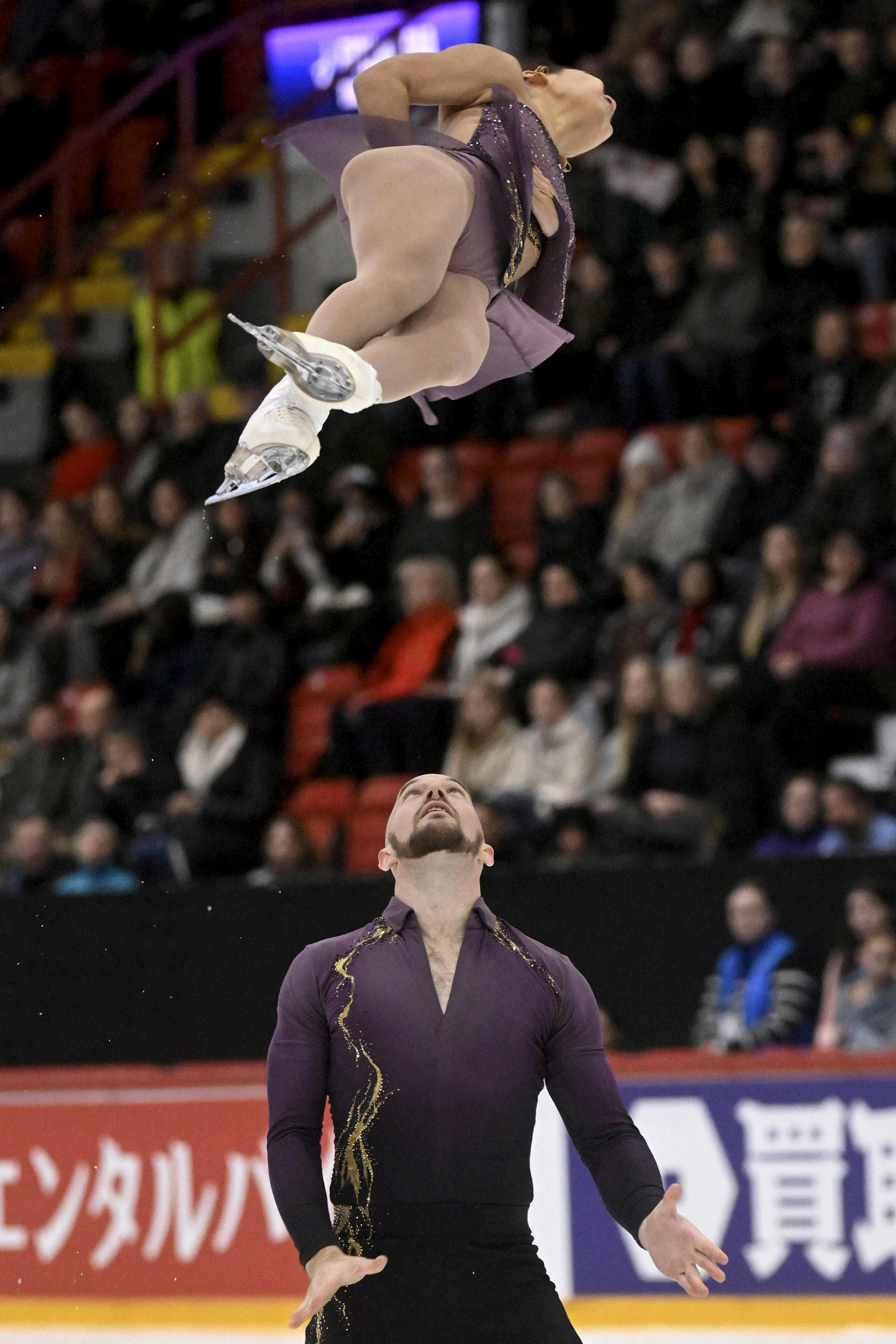 Ellie Kam is airborne over Danny O'Shea during their pairs short program.