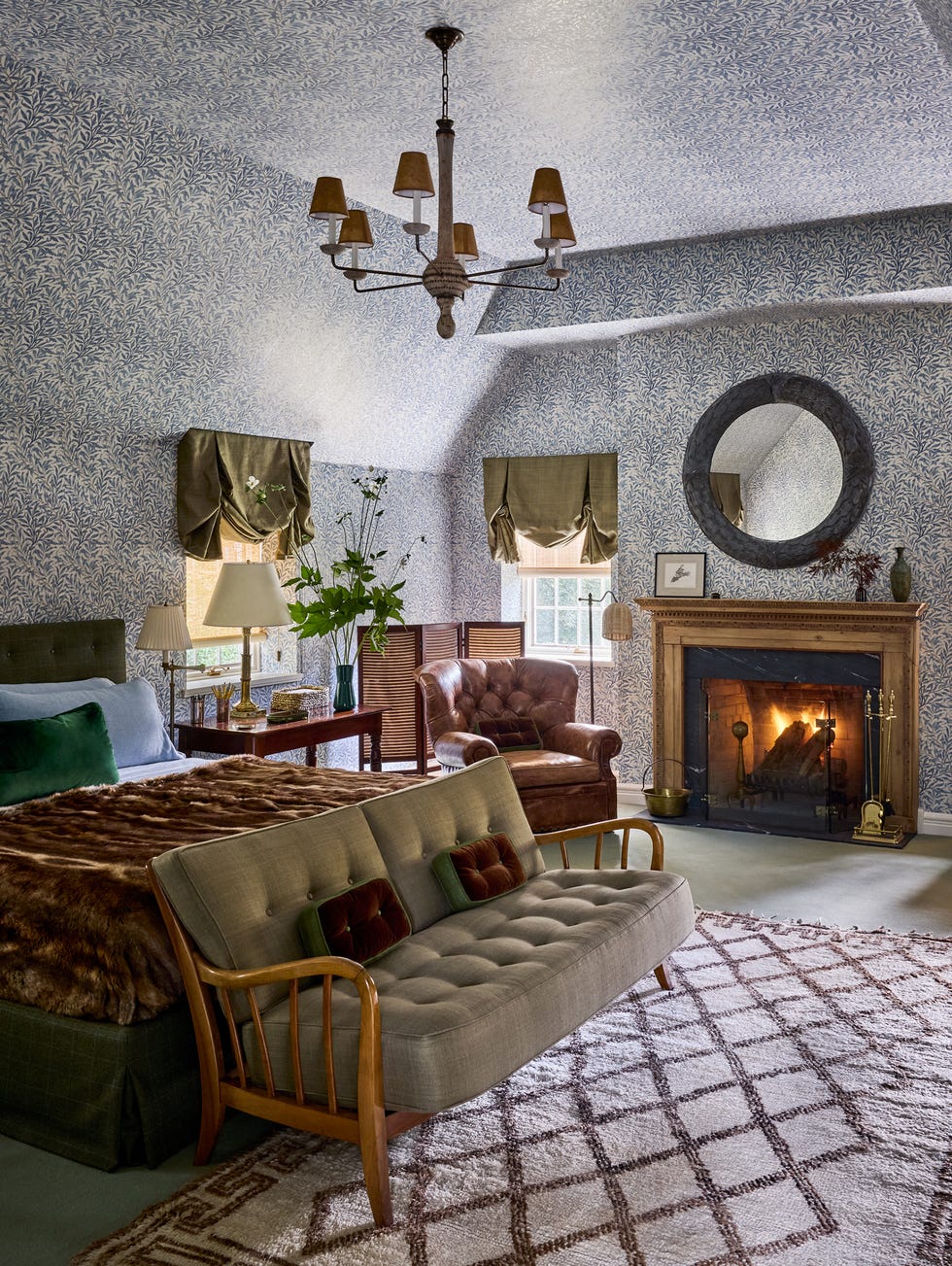 Cozy bedroom with vintage decor, featuring a fireplace and seating area.