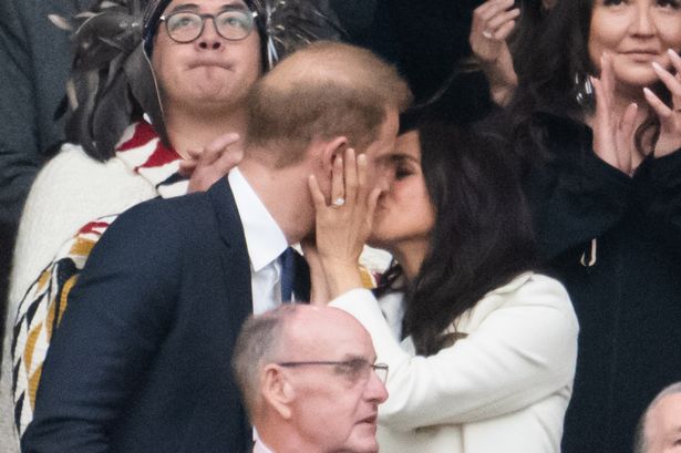 Prince Harry and Meghan Markle sharing a smooch at the Invictus Games 