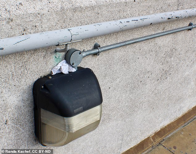 Pictured, light fixture near London Bridge station which 'always had something new in it' - this time, a wedge of paper