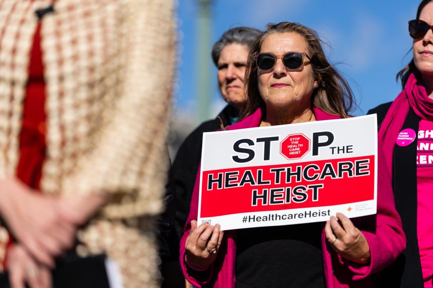 Supporters hold signs during a news conference with Congressional Democrats outside the US Capitol on November 6, 2025.