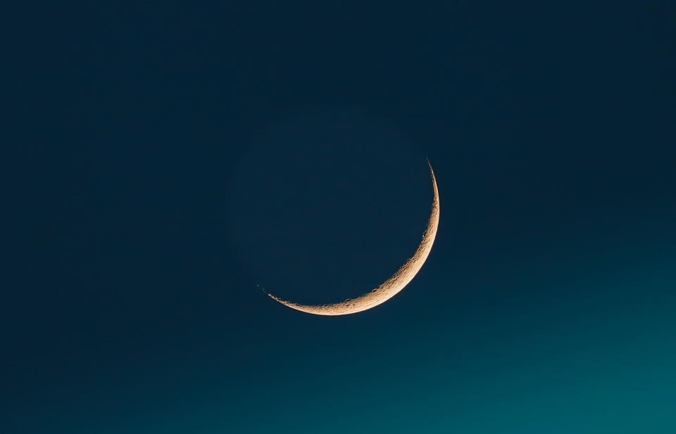 Low angle view of moon against clear blue sky