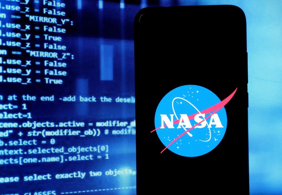 NASA logo seen displayed on a smartphone with programming code on screen behind.