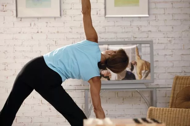 Woman doing yoga to exercise video