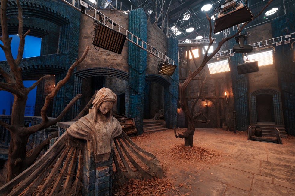 Film set featuring a statue, tree, and various lighting equipment