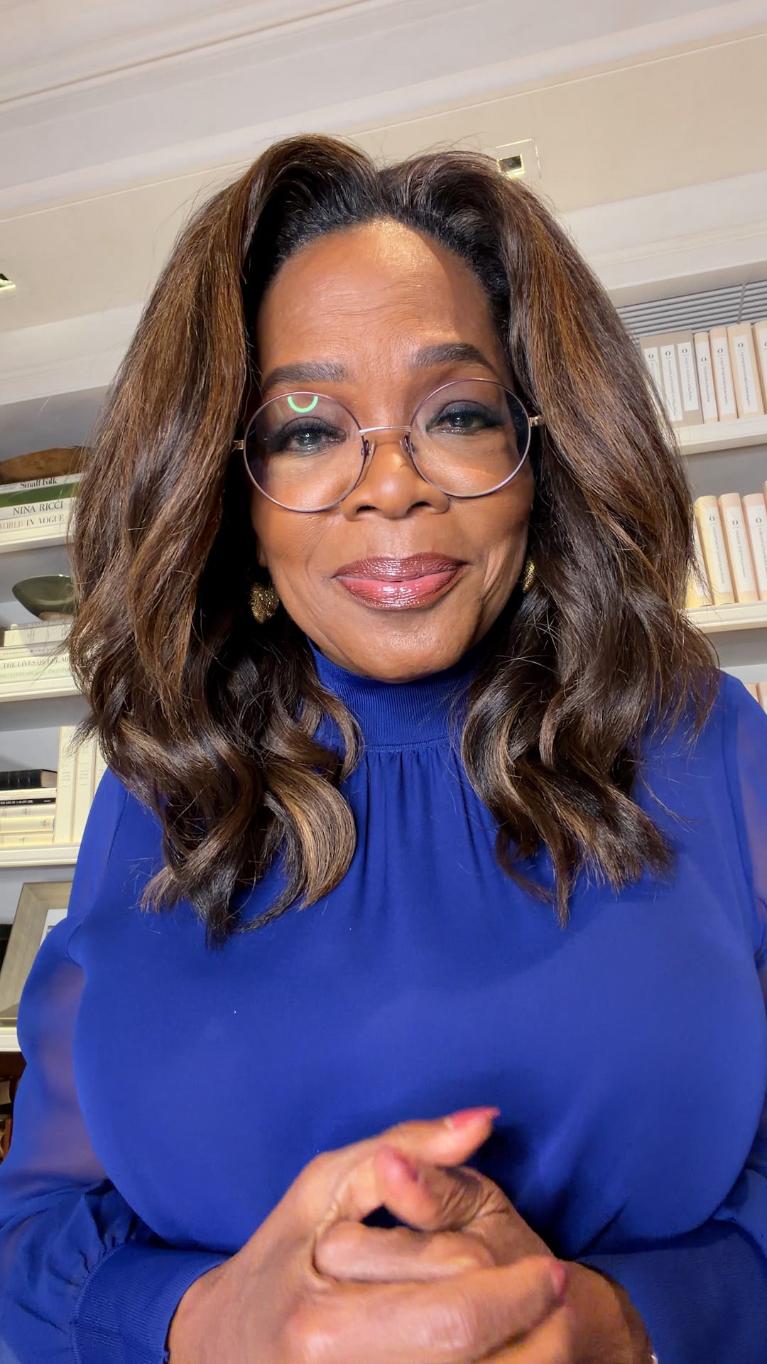 portrait of a person with styled hair wearing a blue sweater