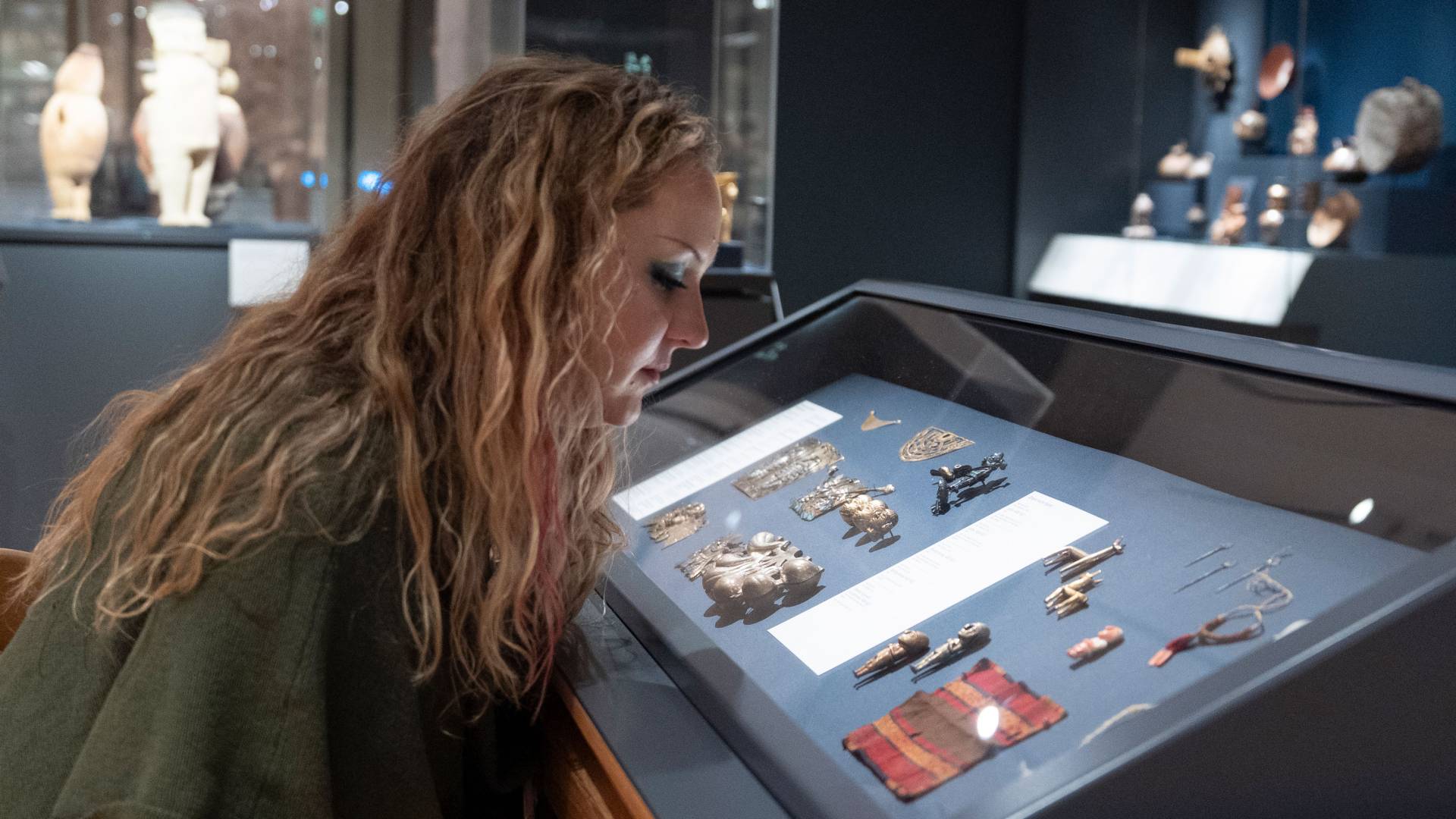 Clara Church sits in front of a case of small 15th- and 16th-century figures.