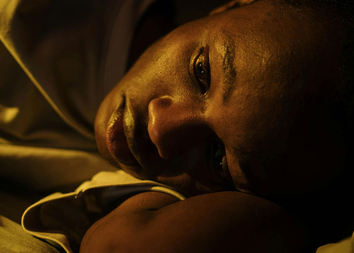 Close-up of a person lying down, capturing a reflective moment in a psychiatric institution setting.
