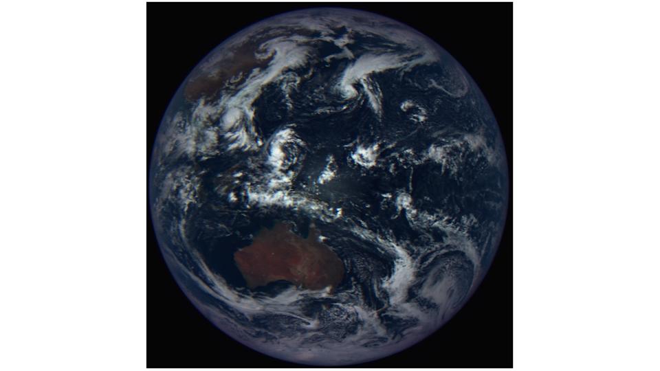 spacecraft photo of earth, showing australia surrounded by cloud-covered seas
