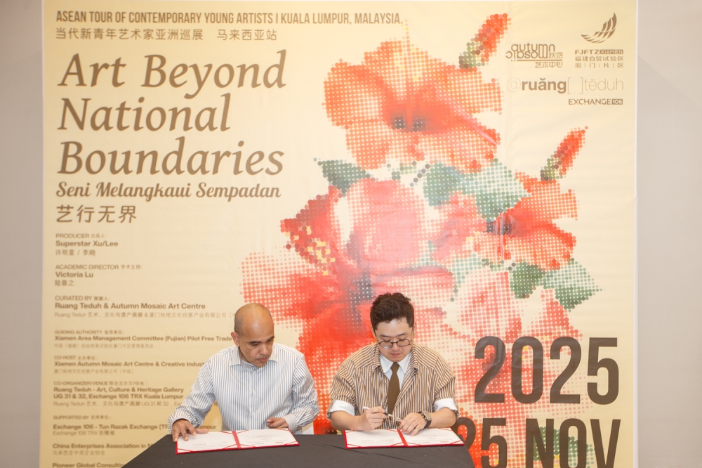 Irwan Muhammad Zain, editorial lead of Seni Malaya (left), and Lee Yang, general manager of Autumn Mosaic Art Centre, sign a memorandum of understanding during the Art Beyond National Boundaries: ASEAN Tour of Young Contemporary Artists from China exhibition at Exchange 106, TRX. — Picture by Raymond Manuel