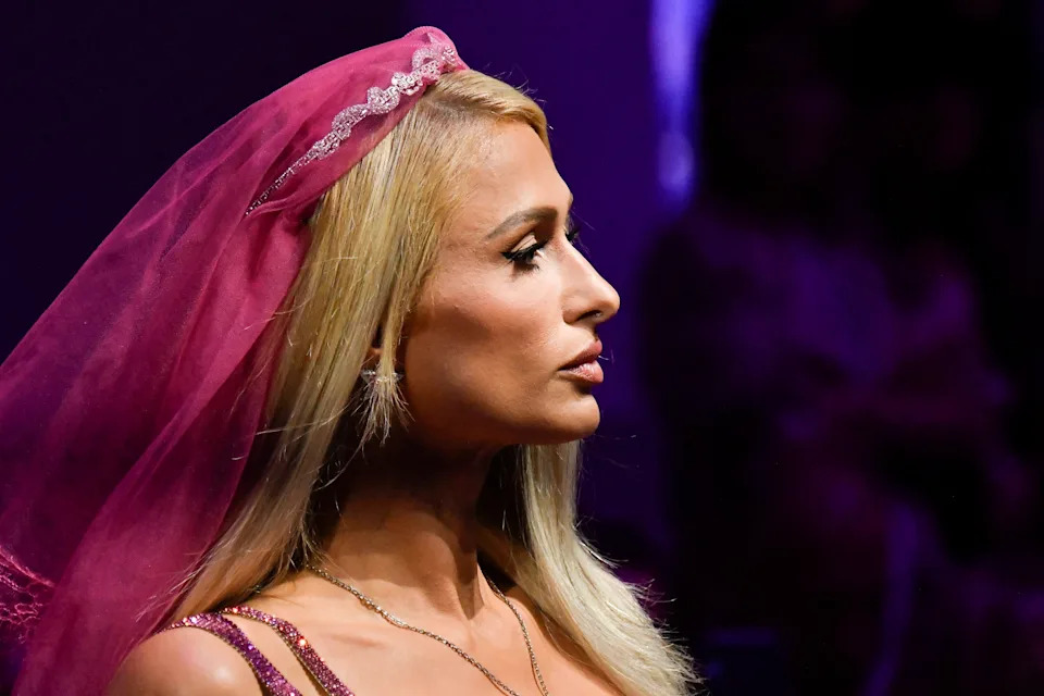 Paris Hilton in profile poses with a veil and glamorous jewelry at a fashion event