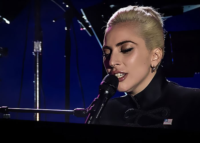 Woman speaking into a microphone during a performance, illustrating unforgettable moments in psychiatric institution work.