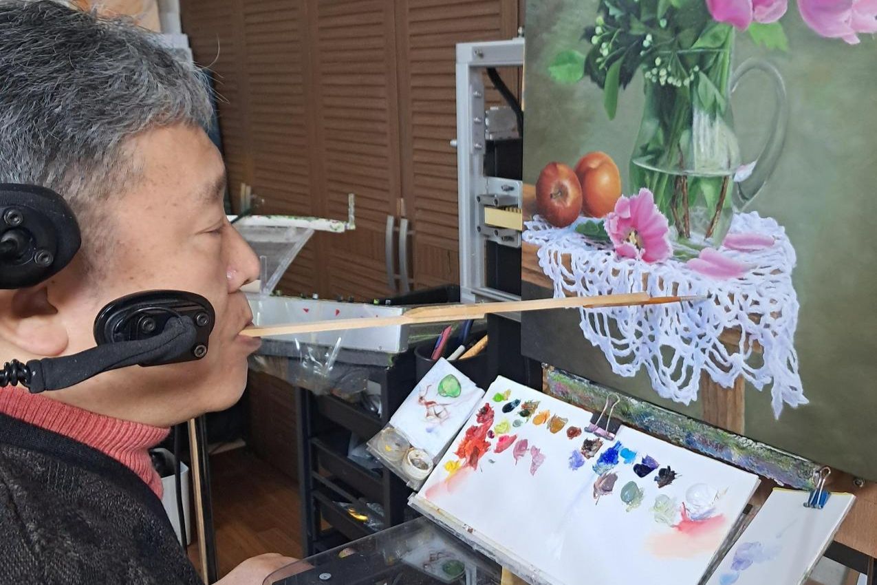 Painter Hwang Jung-eon demonstrates painting with his mouth during an interview at his home in Yongin, Gyeonggi Province, Nov. 27. Korea Times photo by Kim Se-jeong