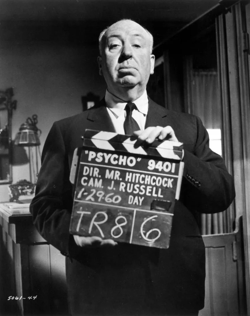 Director Alfred Hitchcock holds a clapperboard on set for "Psycho"