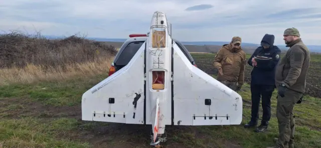 A white Gerbera drone, standing upright, with a red Z painted on the tailfin