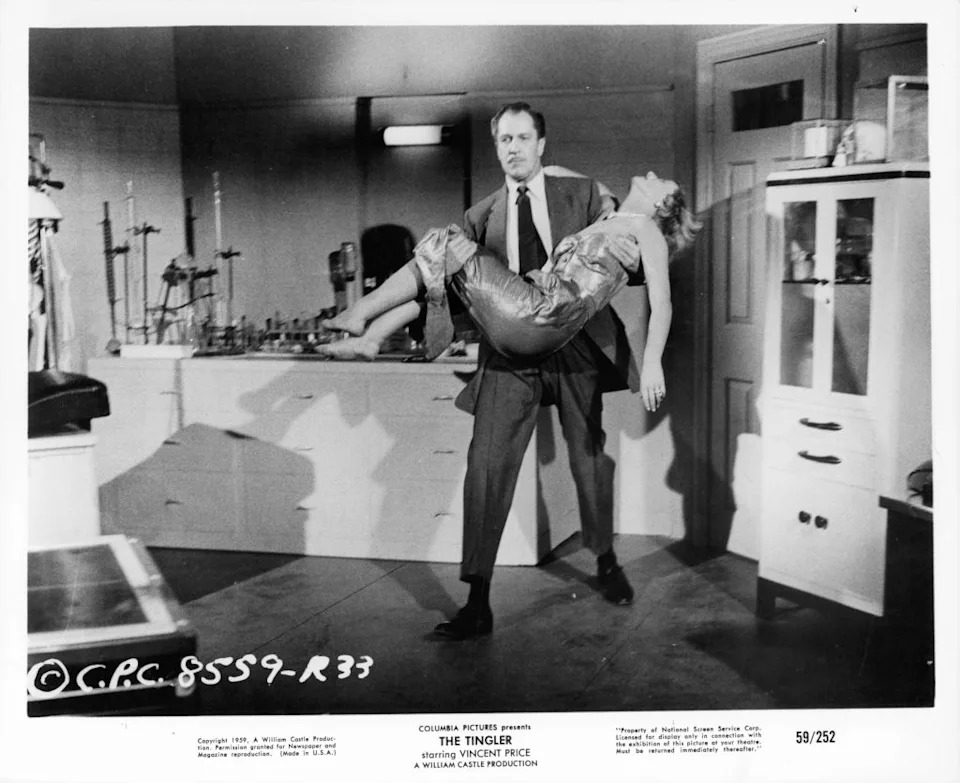 Vincent Price carries a woman in a scene