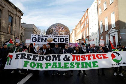 Actor Liam Cunningham leads demonstrators as they hold a banner in support of Palestinians during a march on the International Day of Solidarity, in Dublin, Ireland, on Saturday.