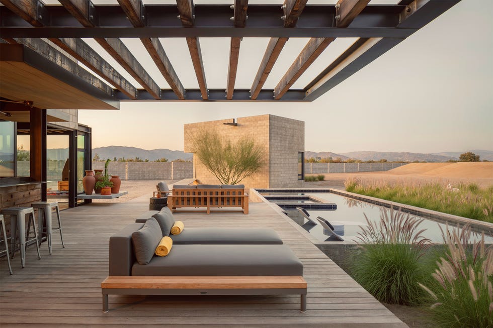 Modern outdoor seating area with pool and landscaping.