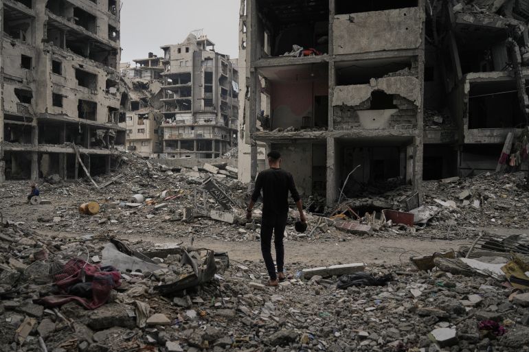 A Palestinian man walks among the ruins of destroyed buildings in Gaza City Monday, Nov. 24, 2025. (AP Photo/Jehad Alshrafi)