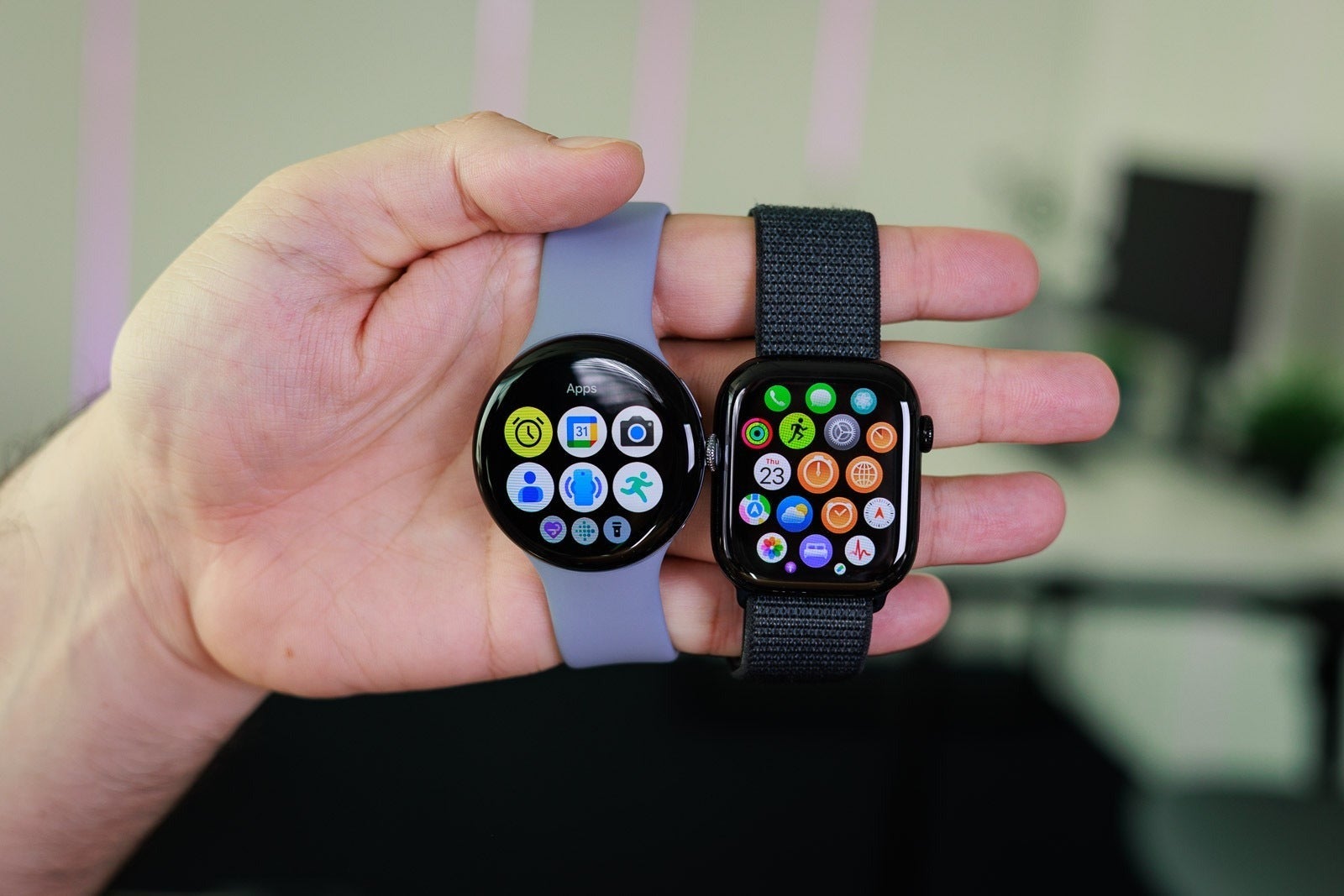 Side-by-side view of a Pixel Watch and an Apple Watch showing their app grids.