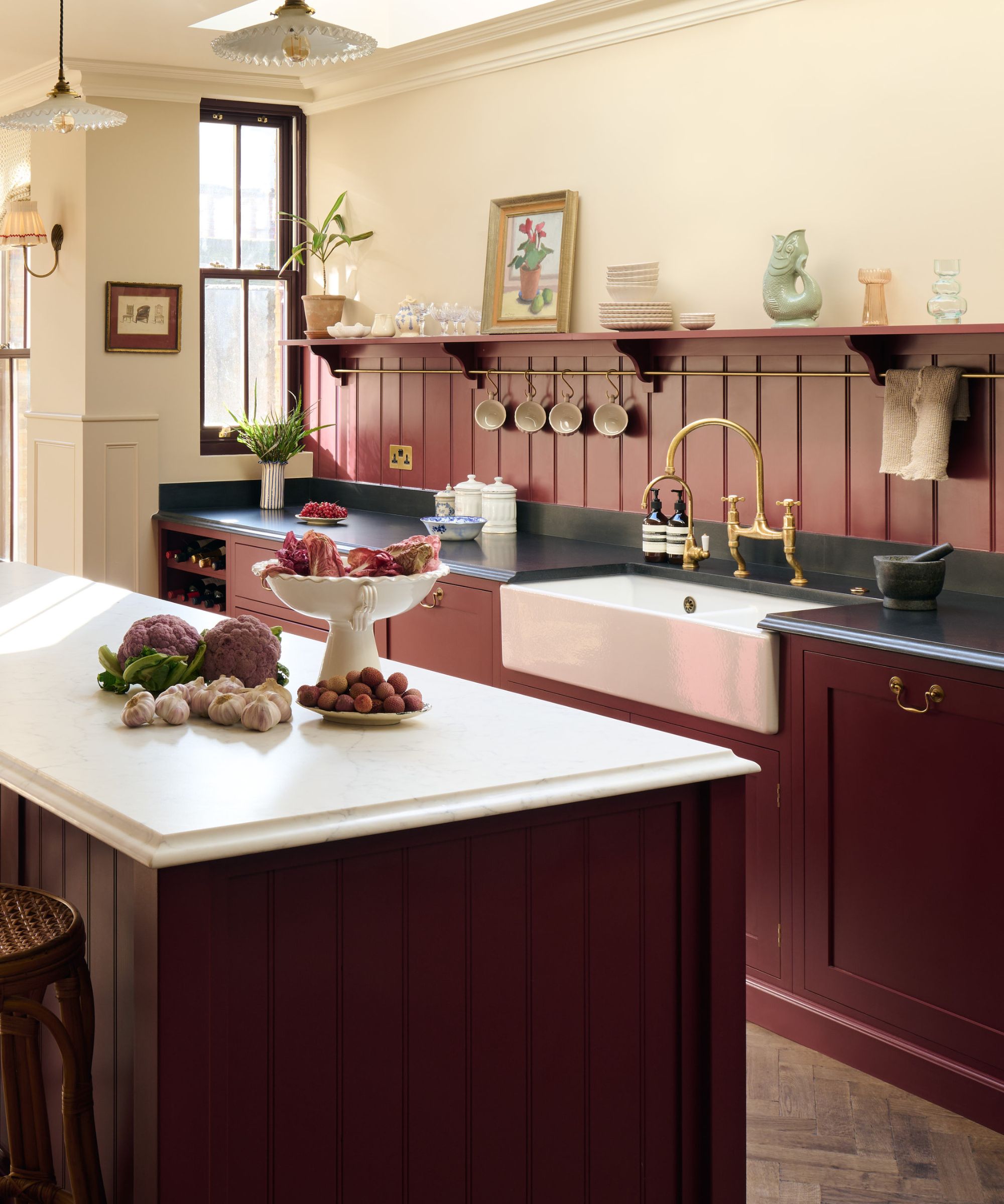 Burgundy kitchen with a paneled backsplash by deVOL Kitchens