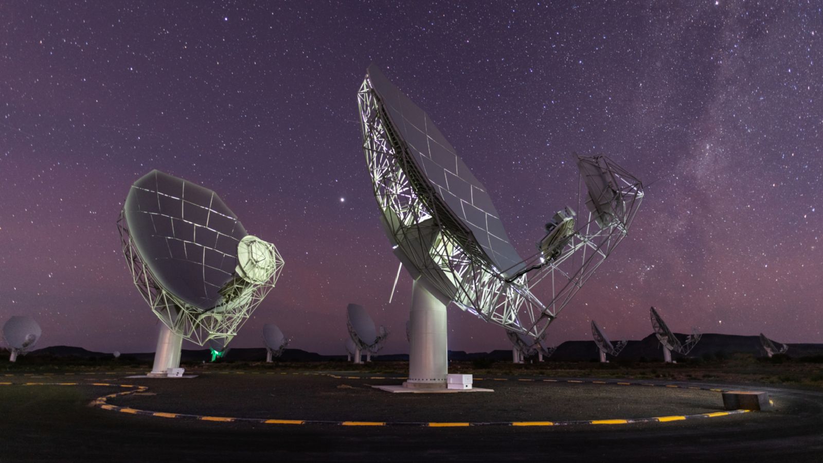 A photo of two radio dishes pointed up at the night sky