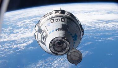 A white and blue Boeing Starliner capsule floats above a blue Earth with the black of space in the background.