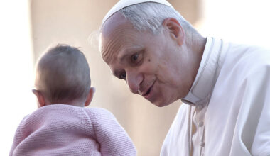 Pope Leo XIV greets a child as he arrives for a Jubilee