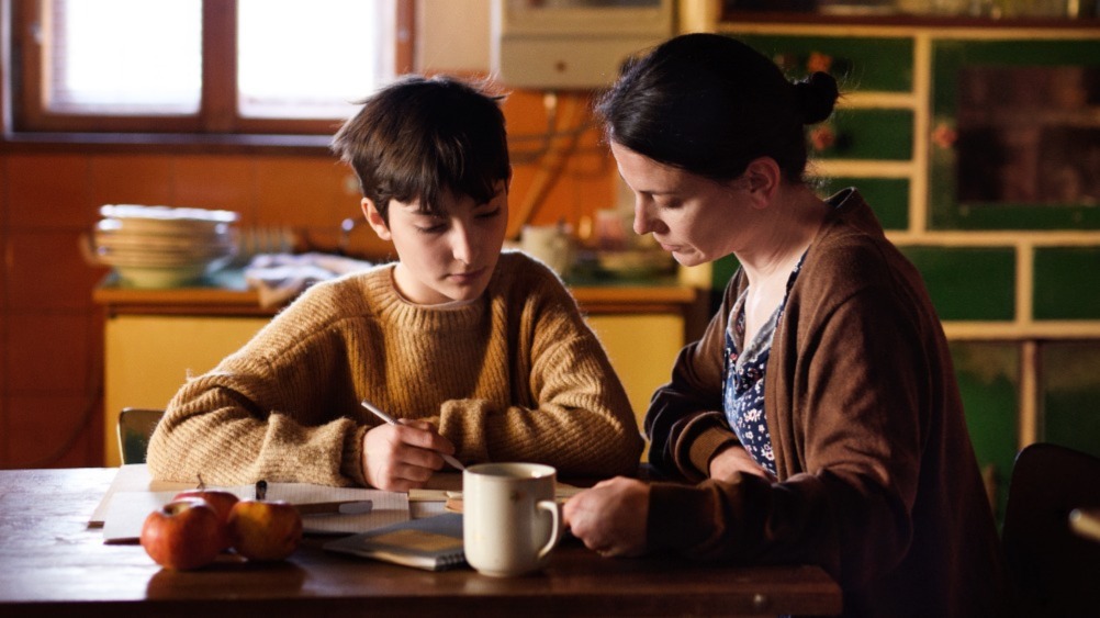 A mother helping her child with the schoolwork.