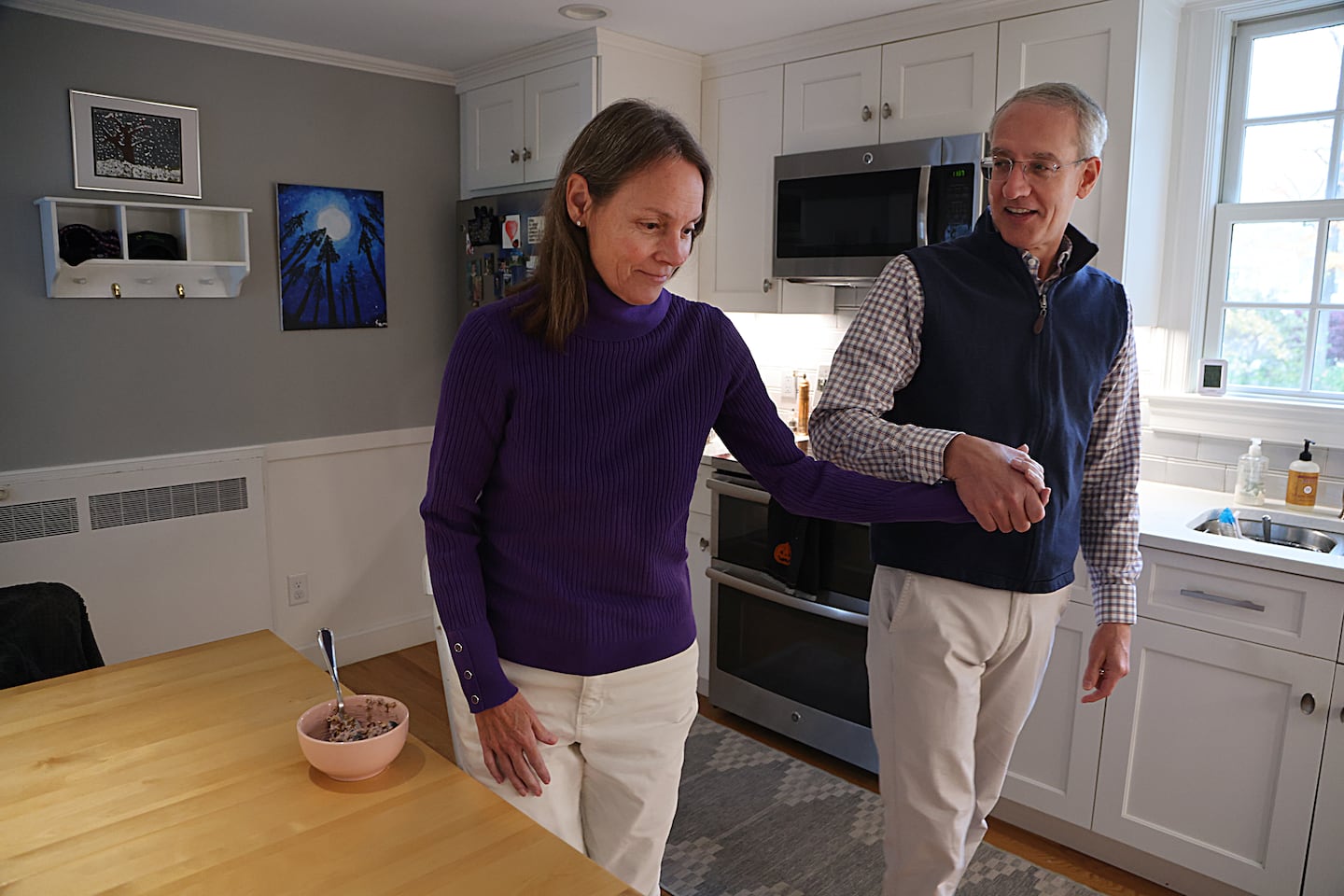 Doug Hano helped his wife, Kirsten, in the kitchen of their home. Doug has struggled to find home care for Kirsten, who was diagnosed at age 53 with early onset Alzheimer's.