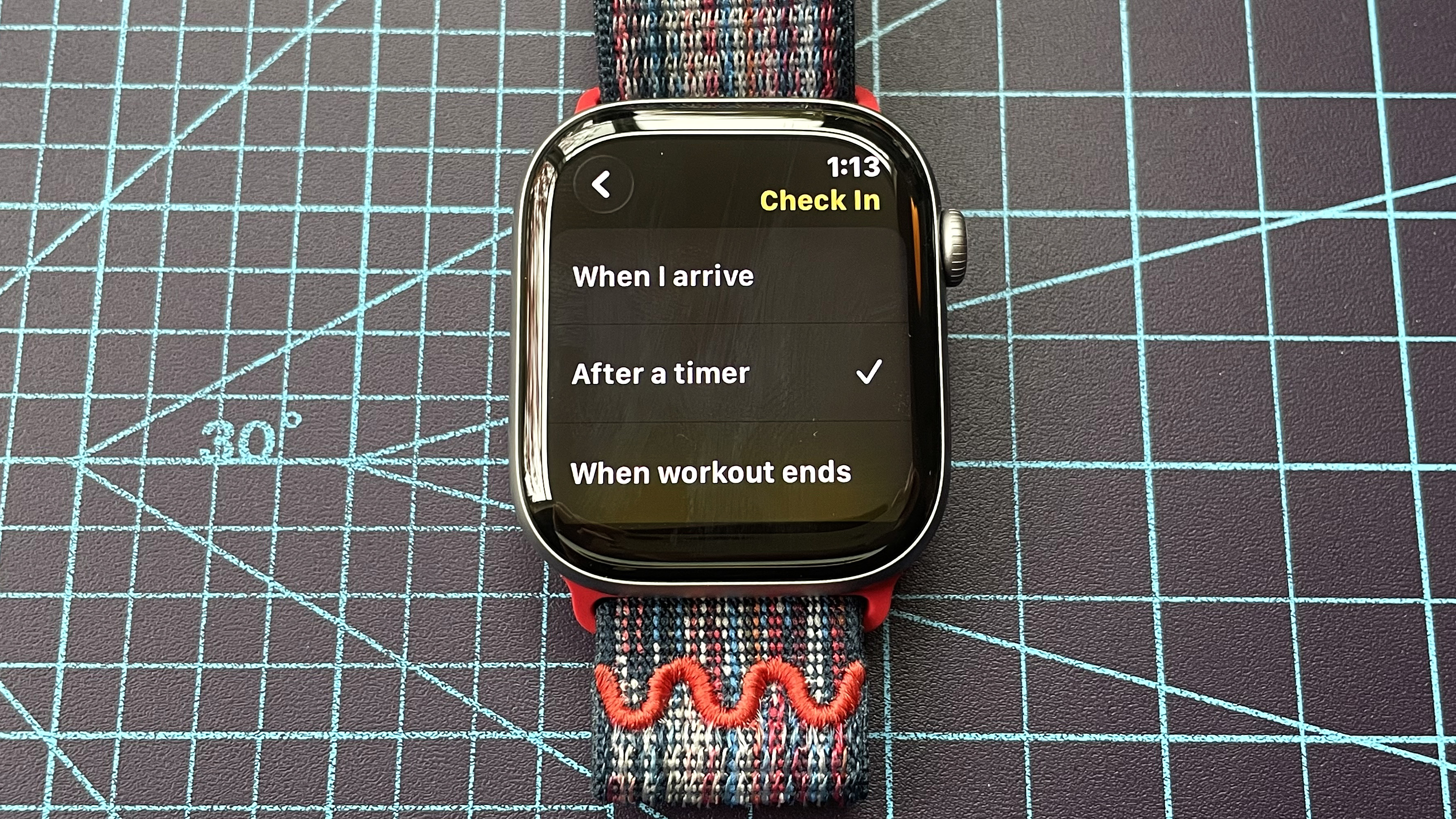 Detail shot of an Apple Watch Series 11 showing the steps to set up and send a Check In safety notification in watchOS 26