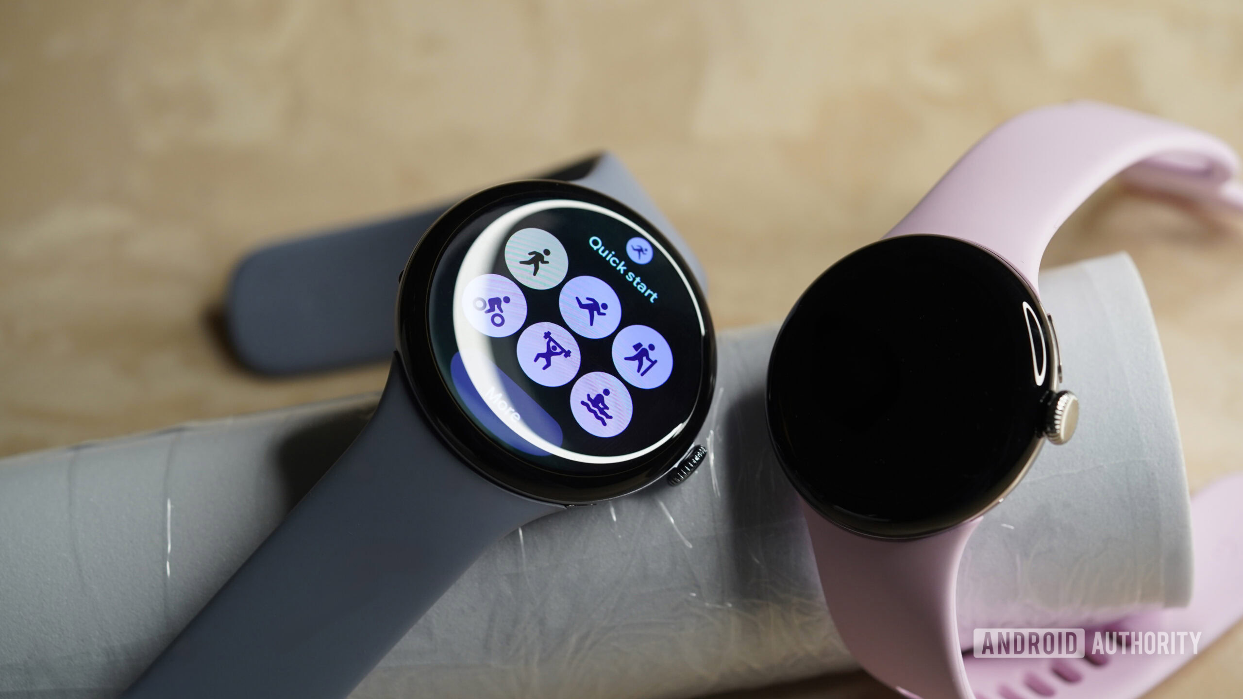 A set of Pixel Watches in two different sizes rest on a surface.