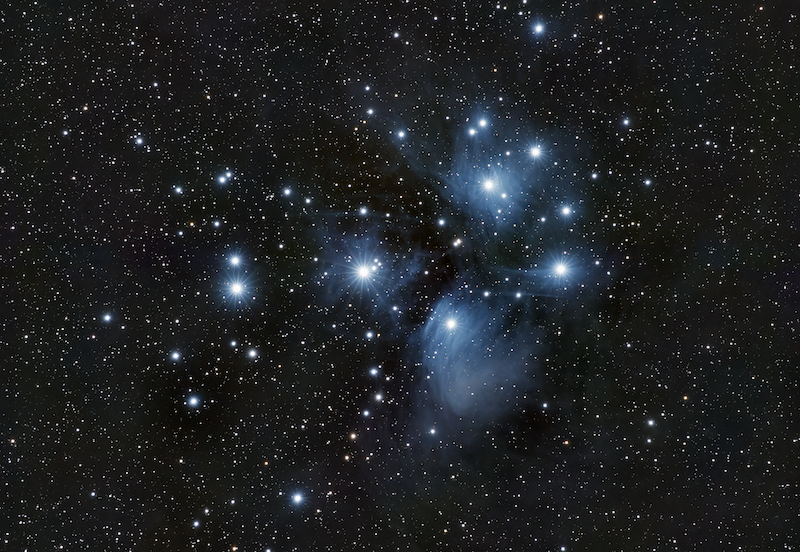 Several bright blue stars surrounded with glowing blue wisps, with many fainter stars in the background.