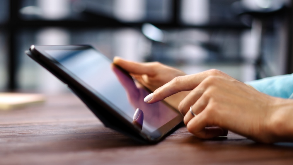 person tapping on tablet screen