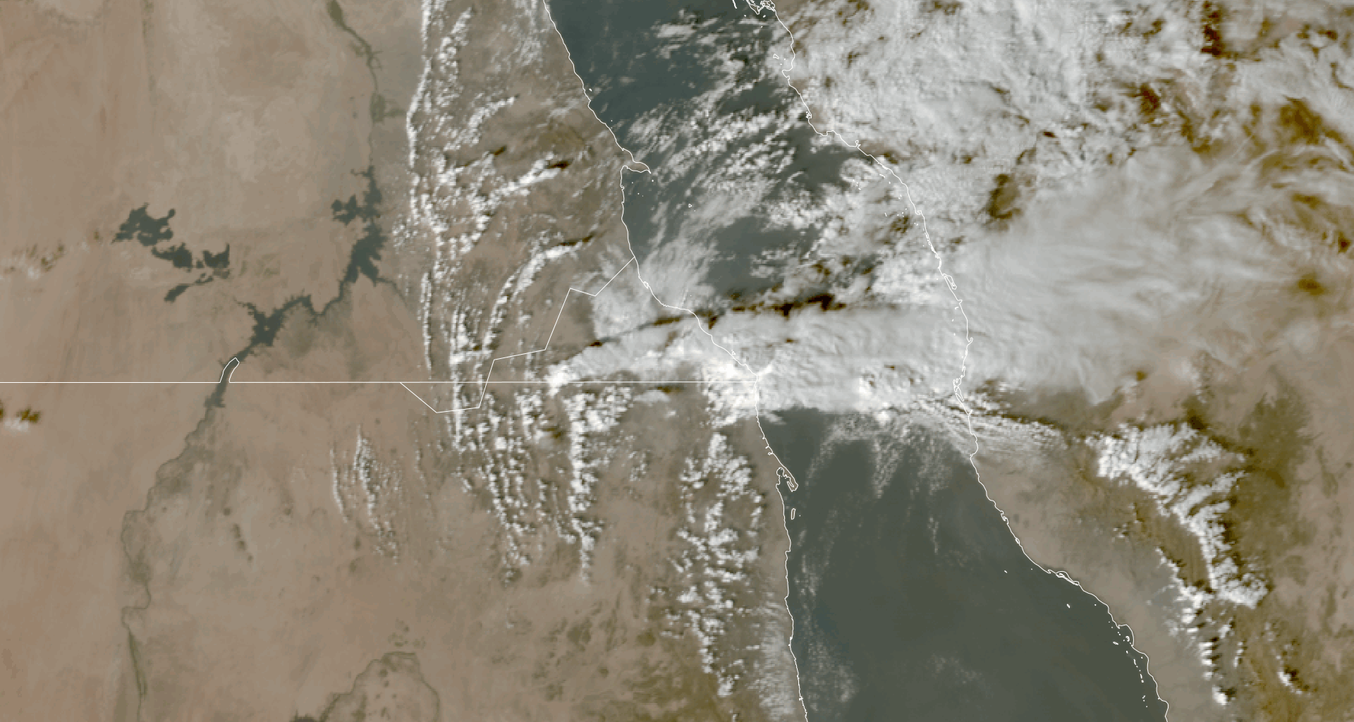 An aerial view of smoky material above two landforms separated by a river.