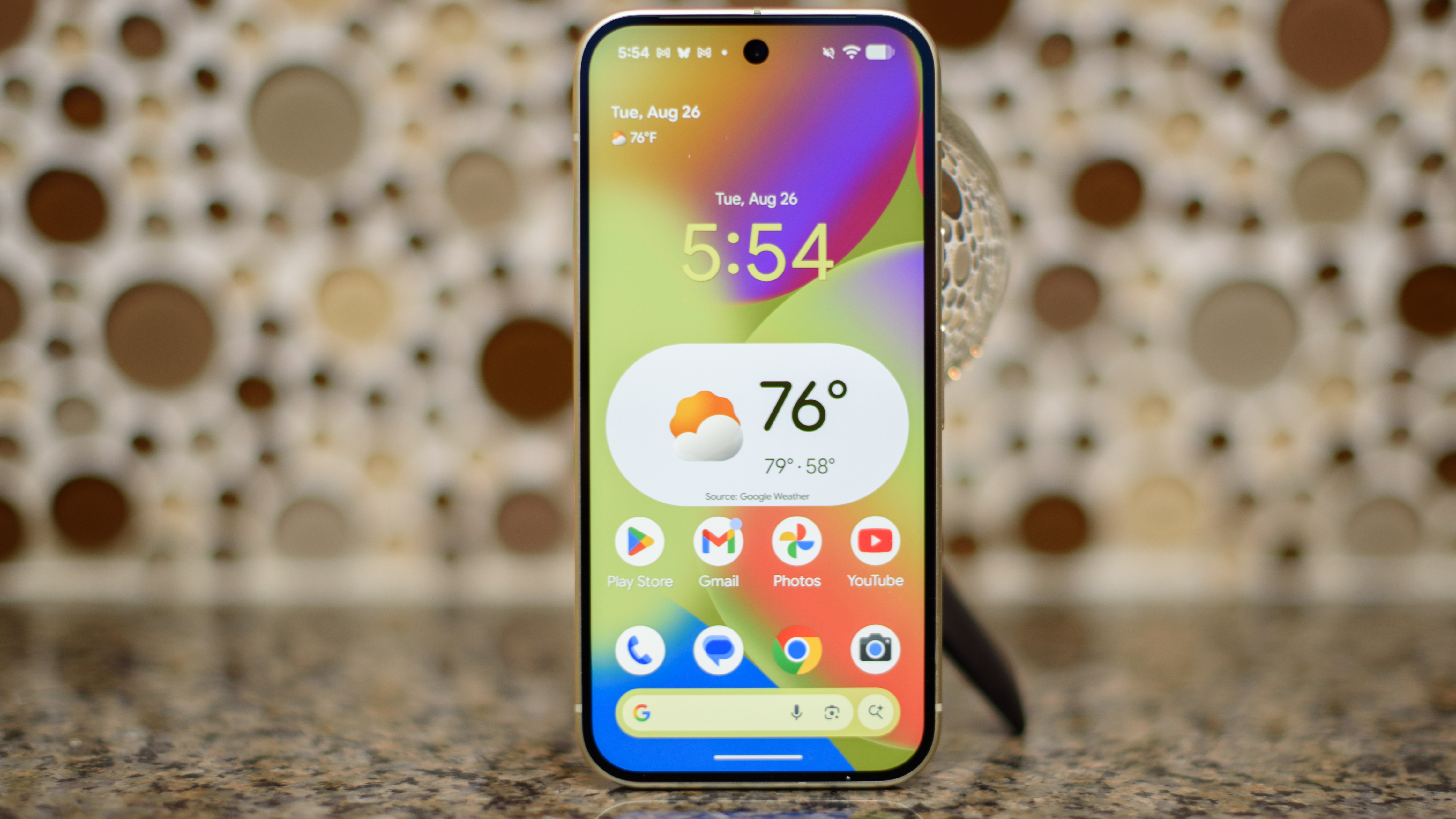 Google Pixel 10 in Lemongrass against a bubbly backsplash