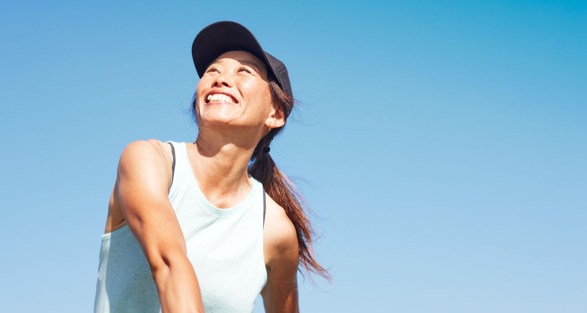 Woman doing vigorous intensity exercise, smiling and laughing outdoors