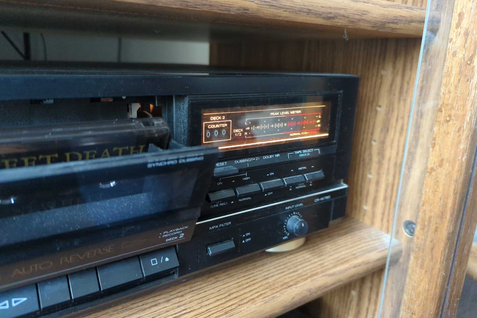 A cassette tape deck player with a bay open and a tape inside.