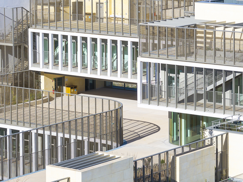 interlocking stone volumes sculpt layered school complex by brenac & gonzalez & associés